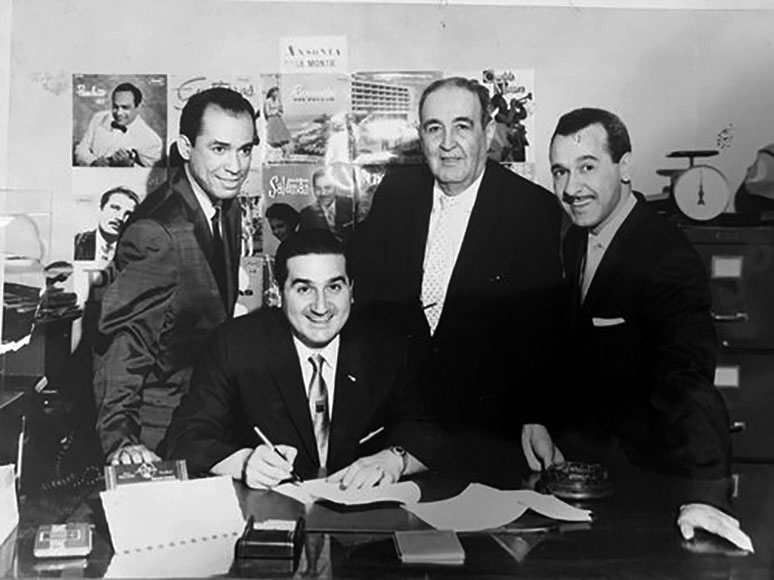 De izquierda a derecha: El compositor dominicano Mario de Jesús Báez, hombre no identificado, Ralph Pérez, hombre no identificado; en la oficina de Ansonia Records, 992 Columbus Avenue, NY, finales de la década de 1950. Cortesía de Gerry Glass.
