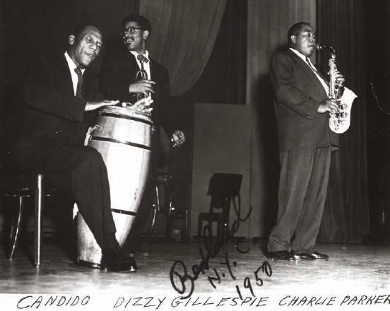 Cándido en las congas, Dizzy Gillespie sonriendo hacia atrás, Charlie Parker sonanco el saxofon. <br>Cortesia del artista. NYC 1950.
